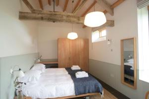 een slaapkamer met een bed met witte lakens en een spiegel bij Clementine in Dorchester