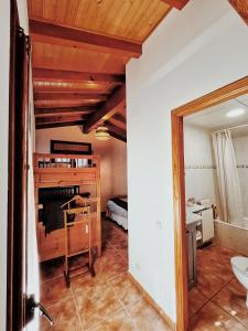 uma sala de estar com uma cama e um espelho em Apartaments Cel i Fusta em Camprodon