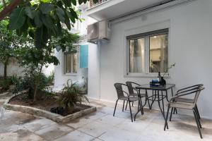 un patio con mesa y sillas frente a una casa en Stylish Abode Under Acropolis W/ Sunny Courtyard! en Athens