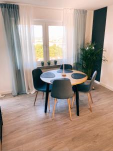 ein Esszimmer mit einem Tisch, Stühlen und einem Fenster in der Unterkunft Apartment- Metzingen in Metzingen