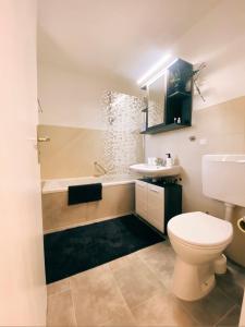 a bathroom with a toilet and a sink and a tub at Apartment- Metzingen in Metzingen