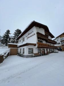 a large building with snow on the ground at Pension Aloisl`s Harmonie in Nauders