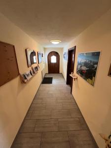 a hallway with a tile floor and paintings on the walls at Pension Aloisl`s Harmonie in Nauders