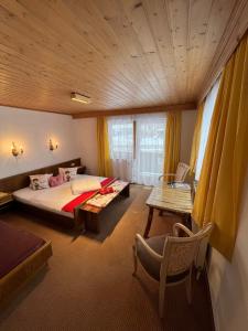a bedroom with a bed and a table and a chair at Pension Aloisl`s Harmonie in Nauders