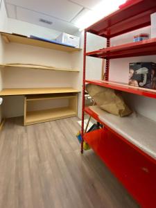 an empty closet with red shelves and wooden floors at Piccolo Nido Falcade in Falcade