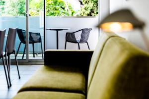 ein Sofa in einem Zimmer mit Tisch und Stühlen in der Unterkunft Apartments Garda Lake in Riva del Garda