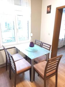 een eettafel met stoelen en een lamp erop bij 2N Appartement in Eupen