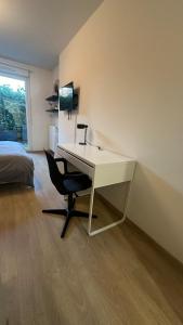 białe biurko z krzesłem w sypialni w obiekcie Appartement à Fleury-Merogis Proche de Paris w mieście Fleury-Mérogis