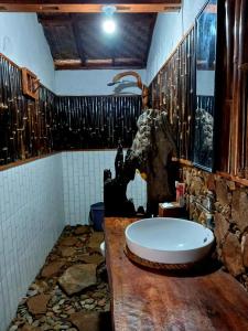 y baño con lavabo y bañera. en Tropical Jungle Hut, en Bukit Lawang