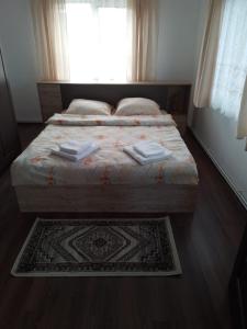 a bedroom with a bed and a window and a rug at Casa Sofi in Vama