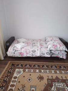 a bed in a room with a rug at Casa Sofi in Vama +3 photos