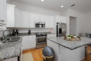 a kitchen with white cabinets and a granite counter top at * Sugar Sands * Steps to Beach * Pool * Balconies * in Panama City Beach