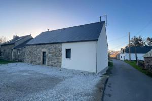 a building with a white door on the side of a street at Pen ar Creac'h in Crozon