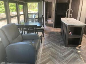 a living room with a couch and a table and a kitchen at Cavendish Luxury Camping in Cavendish