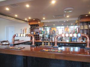 a bar with two copper faucets on a counter at Captain Howey Hotel in Kent