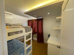 a small room with two bunk beds in it at Cozy 2-bedroom Condo at Marcos Highway in Manila