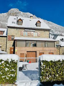 une maison avec de la neige devant elle dans l'établissement Hostal Escuils, à Unha