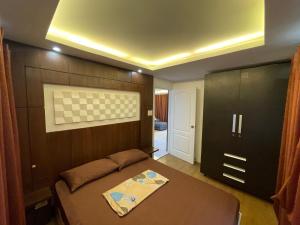 a bedroom with a bed with a wooden wall at Cozy 2-bedroom Condo at Marcos Highway in Manila