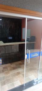 a glass door with a desk with a computer on it at Pousada Vivenda in Olímpia