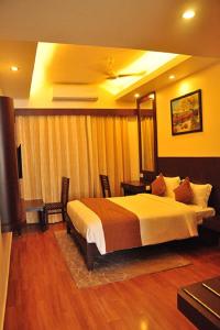 a hotel room with a bed and a table and chairs at RKN Hotel in Pondicherry