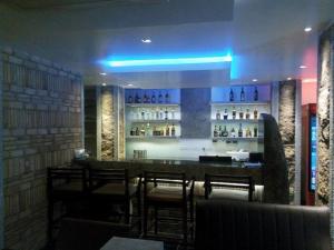 a bar in a restaurant with some chairs and lights at RKN Hotel in Pondicherry