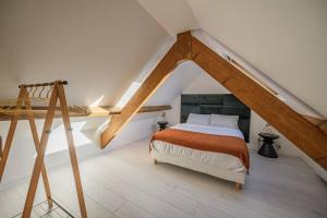 - une chambre mansardée avec un lit et une échelle dans l'établissement Le Duplex, proche centre-ville, à Quimper