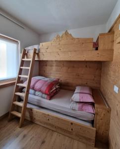 Litera de madera con escalera en una habitación en Casa Al Rin, en Valdidentro