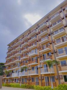 a large building with palm trees in front of it at Palawan Paradise Condotel 1L in Puerto Princesa City