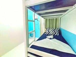 a small bedroom with a blue and white bunk bed at Palawan Paradise Condotel 1L in Puerto Princesa City