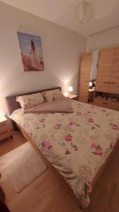 Bosanska DubicaにあるApartman Centar Kozarska Dubicaのベッドルーム1室(花の咲く大型ベッド1台付)
