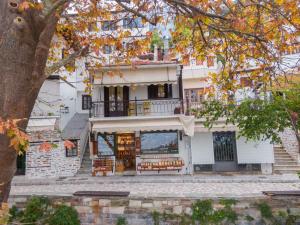 a large white building with a balcony on top at Toma's House in Volos