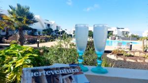 VillaverdeにあるCasa Ana - Luxury pool apartment at Casilla de Costaのプールサイドのテーブルに座ったワイングラス2杯