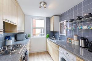 a kitchen with a sink and a stove top oven at Birch South Lanes - Super 2 bed duplex with south terrace in Brighton & Hove