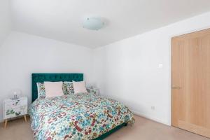 a white bedroom with a bed with a green headboard at Birch South Lanes - Super 2 bed duplex with south terrace in Brighton & Hove