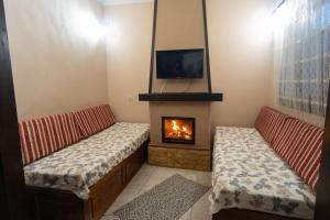 ein Wohnzimmer mit 2 Bänken und einem Kamin in der Unterkunft Toma's House in Volos