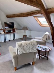 een woonkamer met 2 stoelen en een tafel bij Villa Capucine in Aubigny-sur-Nère