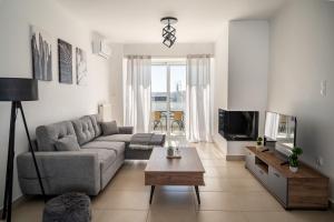 a living room with a couch and a tv at Elegant apartment with breathtaking cityscape view (Drap_F5) in Piraeus