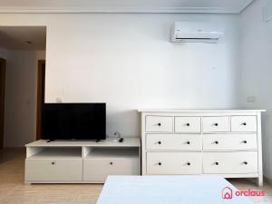 een slaapkamer met een witte dressoir en een televisie. bij El Oasis in Oropesa del Mar