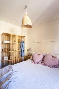 Un dormitorio con una cama con almohadas rosas. en Agave Marina, en Marciana Marina