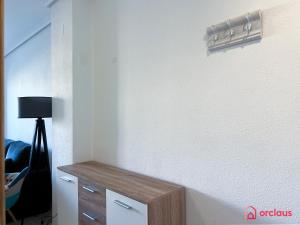 een kamer met een witte muur met een tafel en een lamp bij El Oasis in Oropesa del Mar