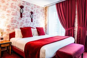 Schlafzimmer mit einem großen Bett und roten Vorhängen in der Unterkunft Maison Eugenie in Paris