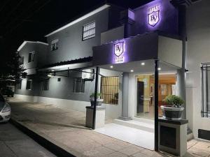un edificio con un letrero púrpura en el costado. en Hotel Bellavista en Villa Carlos Paz