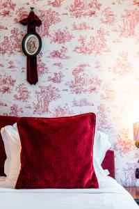 une horloge sur un mur à côté d'un lit dans l'établissement Maison Eugenie, à Paris