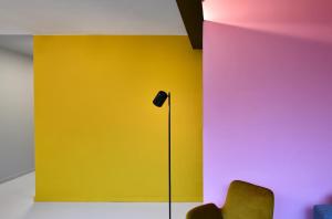a room with a yellow wall and a lamp at NEOZONE Neostudio Malmedy in Malmedy