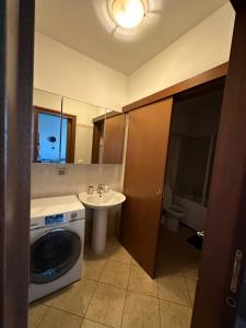 een badkamer met een wasmachine en een wastafel bij Da Vanessa in Lido degli Estensi