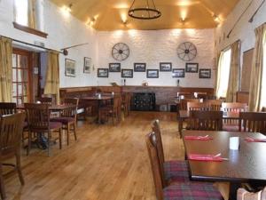 uma sala de jantar com mesas e cadeiras num restaurante em The Ken Bridge Hotel em New Galloway