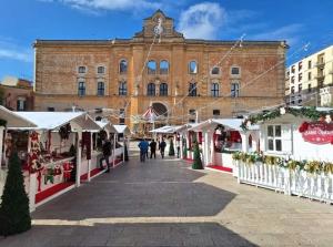 uma rua com mercados de Natal em frente a um edifício em Martini Matera 2 punto 0 em Matera