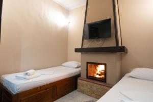 a room with two beds and a fireplace at Toma's House in Volos