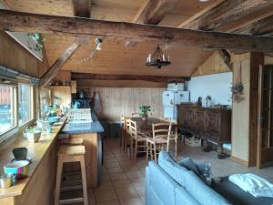 een keuken en een woonkamer met een bank en een tafel bij Charmant duplex 70m2,type châlet savoyard in Bourg-Saint-Maurice