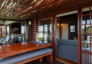 Una sala de estar con una mesa y un sofá azul. en Villa Mtati, en Port Alfred